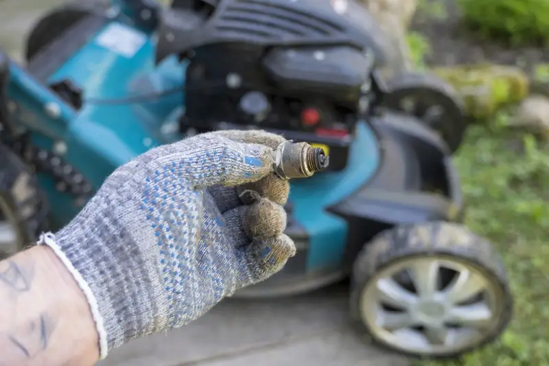 lawn mower repair technician holding engine part in a bright workshop