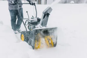 Snowplow. Man removes snow with a snowblower in winter day